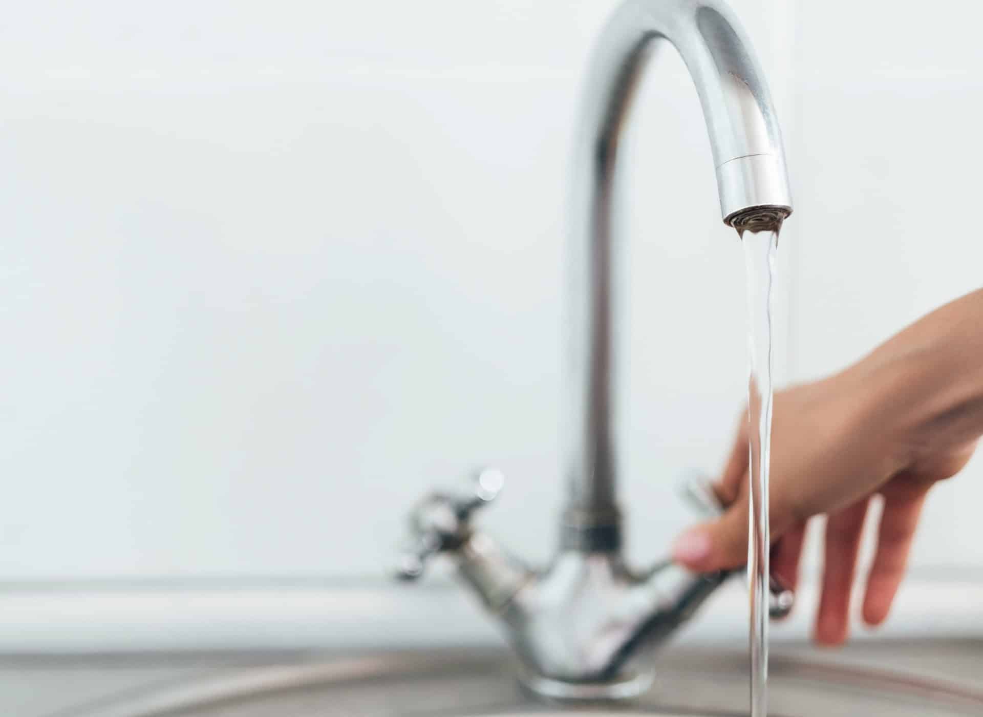 Wasserhahn mit fließendem Trinkwasser zum Thema Kontrolle und Wasserqualität
